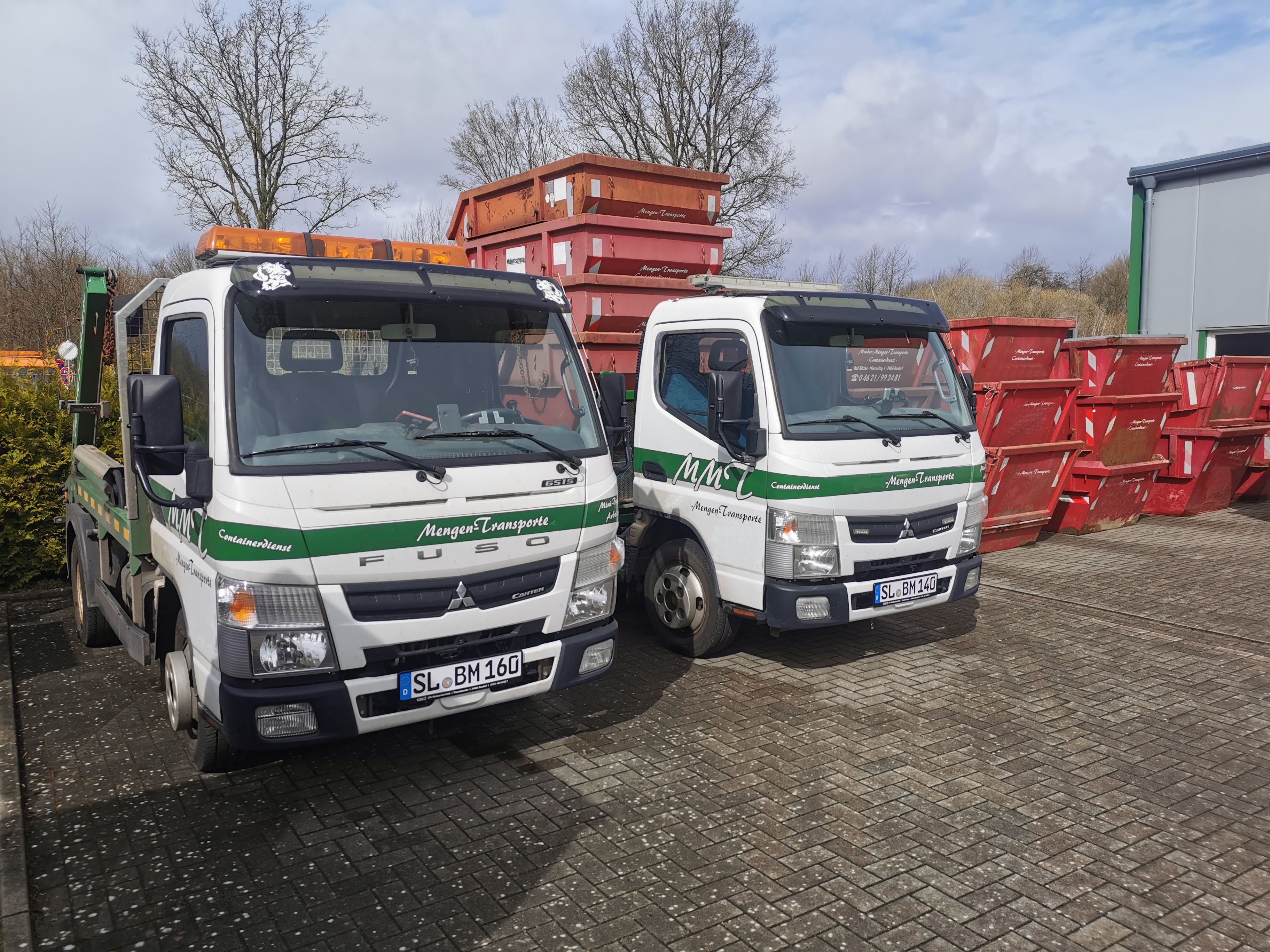 Fahrzeuge und Container von Maass-Mengen-Transporte auf dem Betriebsgelände